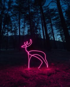 a neon deer standing in the middle of a forest