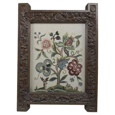 an ornate wooden frame with flowers and leaves