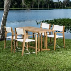 a wooden table and chairs sitting in the grass