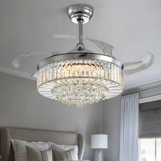 a crystal chandelier hanging from the ceiling in a bedroom