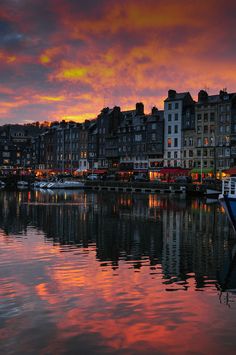 the boats are docked in the harbor at sunset or sunrise time as the sun sets