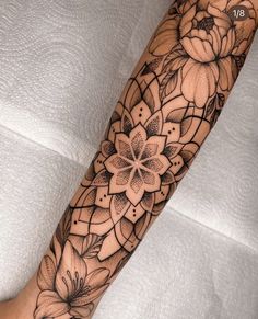 a woman's arm with flowers on it and an intricate design in the middle