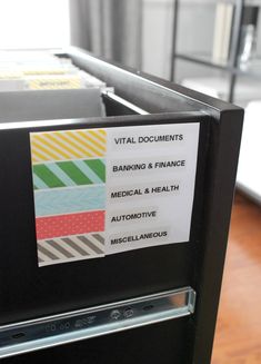 a black filing cabinet with labels on it