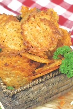 some fried food is in a basket on a checkered tablecloth with parsley