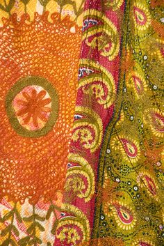 an orange, yellow and green piece of cloth with designs on it's sides