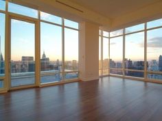 an empty room with large windows overlooking the city