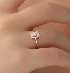 a woman's hand with a diamond ring on it