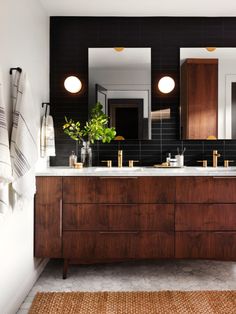 a bathroom with two sinks, mirrors and towels on the counter top in front of it