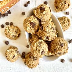 cookies and chocolate chips in a bowl on a white surface with an orange book next to it