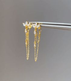 The pair you'll reach for again and again. Add a touch of sparkle to your life with these shimmering gems, designed to complete any look. Handcrafted with a sterling silver base, 14k gold plating and cubic zirconia, these earrings are truly one of a kind. Measuring 40mm in height, they are the perfect accessory to dress up any outfit. Whether you're heading to a party or just running errands, these earrings will add a touch of elegance to your day. Silver Crystal Gold Plated Earrings For Party, Silver Gold-plated Crystal Earrings For Party, Delicate Gold Earrings For Party, Sterling Silver Plated Crystal Earrings Gift, Silver Plated Earrings As Gift, Fine Jewelry Dangle Crystal Earrings With Cubic Zirconia, Silver Plated Earrings For Gift, Gift Sterling Silver Crystal Earrings, Dainty Yellow Gold Earrings For Party