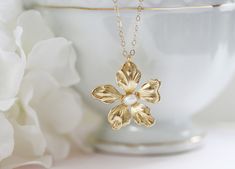 "This sweet little pendant necklace features a gold plated daisy flower hand wired wrapped with a creamy white fresh water pearl. Great gift for the flower lover in your life. Wonderful spring bridesmaid's necklace. Hangs from a fine 14 karat gold filled chain. Spring clasp closure The daisy is 1 \" wide ** The last photo show's a different pansy same size with a bird charm . Spring closure clasp Photoed with a 16\" chain on model H A N D M A D E * We hand make all pieces in our Water Mill New Y Flower Pearl Necklace, Gold Flower Necklace, Pearl Flower Pendant, Bridesmaid Pearls, Water Mill, Daisy Necklace, Necklace Flower, Bird Charm, Gold Jewelry Necklace