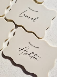 four white ceramic coasters with writing on them