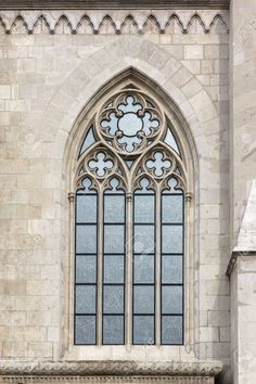 an ornate window in the side of a stone building