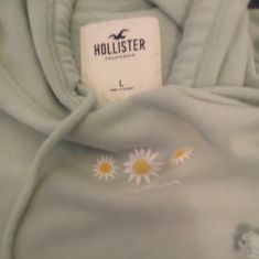 Sage Green Hoodie From Hollister With Embroidery Of Flowers On Front Along With Logo Cute Hoodie With Drawstring Hood For Spring, Green Hoodie Tops For Spring, Spring Green Hoodie Top, Cute Spring Sweatshirt With Drawstring Hood, Spring Embroidered Hooded Hoodie, Embroidered Hooded Hoodie For Spring, Cute Spring Hooded Sweatshirt, Cute Hooded Sweatshirt For Spring, Spring Cotton Hoodie