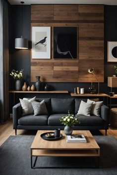 a living room with black couches and wood paneling on the wall behind it