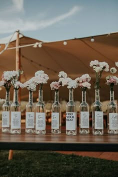 there are many bottles with flowers in them on the table