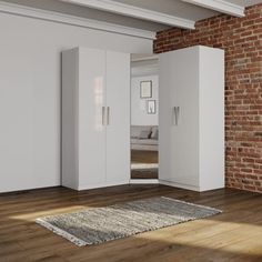 an empty room with brick walls and white furniture in the corner, including a large rug