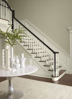 there is a vase with flowers on the table in front of the stair railings