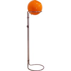 an orange lamp on a metal stand against a white background