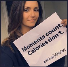 a woman holding up a sign that says, moments count calories don't