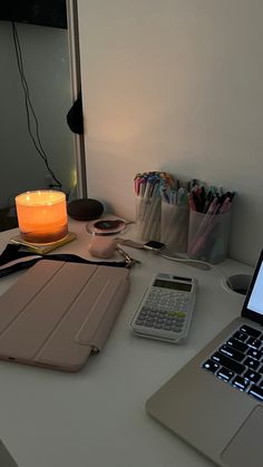 an open laptop computer sitting on top of a desk next to a cell phone and calculator