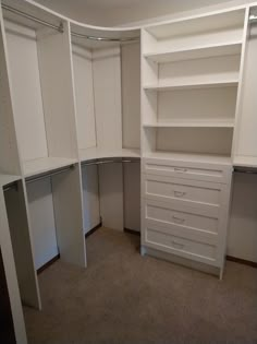 an empty closet is shown with white cabinets and drawers on the bottom half of it