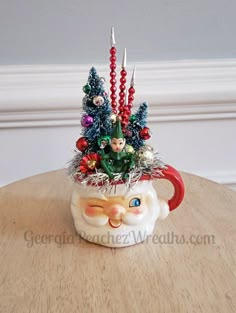 a coffee cup with christmas decorations on it and a candle holder in the shape of santa's head