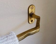 a close up of a gold handle on a white wall with a knitted arm