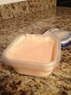 a plastic container sitting on top of a counter next to a blue bowl filled with food