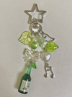 a wine bottle with charms attached to it and a star hanging from the side on a wall