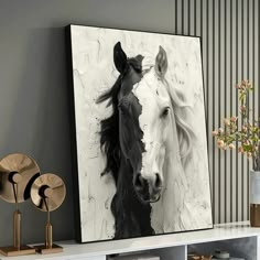 a black and white photo of a horse on a wall next to a vase with flowers