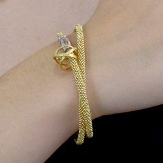 In the fashion world we don't often see the words "unique" and "comforable" in the same sentence, but this bracelet is both. A flexible woven gold or silver band wraps twice around your wrist and fastens easily with a secure magnetic clasp. One of the artist's signature Mobius charms in 22k gold vermeil or sterling silver is threaded onto the band for decoration. Created by San Francisco jewelry designer Kathleen Maley, handmade in USA. Designer details → Elegant Bracelets With Interwoven Design As Gift, Elegant Bracelets With Interwoven Design For Gift, Modern Gold Bracelet As Gift, Adjustable Interwoven Bracelets As Gift, Modern Twist Gold Bracelet As Gift, Adjustable Jewelry With Interwoven Design For Gifts, Elegant Spiral Hand Wrapped Jewelry, Gold Jewelry With Interwoven Design As Gift, Gold Interwoven Jewelry Gift