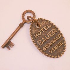 an old key is attached to a hotel plaque that says, hotel bauer grunwald vienna