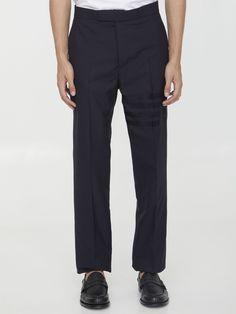 Straight-leg pleated trousers in navy blue wool with 4-Bar detail on left leg. It features button and hook closure, two side welt pockets, two rear buttoned welt pockets and adjustable backstrap detail. Tricolor grosgrain loop tab detail at the back. Regular fit. The model is 190cm tall and wears size 02. Size nationality: US Product number: 3515625 Product code: MTC001A06146420 Composition: 100% WOOL Tailored Navy Dress Pants With Welt Pockets, Navy Tailored Dress Pants With Welt Pockets, Navy Business Bottoms With Welt Pockets, Navy Tapered Leg Dress Pants For Formal Occasions, Classic Navy Bottoms For Office, Navy Business Pants With Pockets, Business Navy Pants With Pockets, Classic Navy Bottoms With Straight Hem, Classic Navy Dress Pants For Business Casual