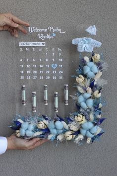 a calendar is displayed on a wall with flowers and candles in the shape of a wreath