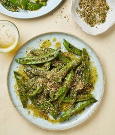 two plates with green beans and seasoning on them