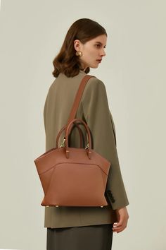 European Elegance in Every Stitch: Your Go-to Winged Tote Unveiling our chic European winged tote handbag, meticulously crafted from superior calfskin leather, exuding timeless pure color aesthetics. The handy zip closure coupled with modern stitch detailing seamlessly marries convenience with vogue. Available in versatile shades of brown, khaki, green, and black, its interior is thoughtfully designed with card slots, a zipper pocket, and a main compartment, ensuring your belongings are organize European Elegance, Just Style, European Design, European Designs, Shades Of Brown, Tote Handbag, Leather Care, Khaki Green, Pure Color