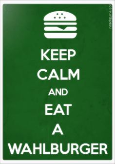 a green sign that says keep calm and eat a hamburger on the bottom right hand corner