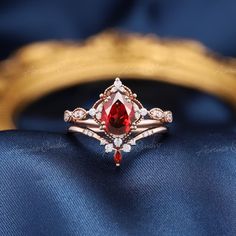 a close up of a ring with a red stone in the middle and white diamonds around it