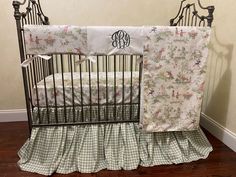 a baby crib with matching bedding and curtains in the corner, next to a wooden floor