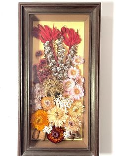 a painting of flowers in a wooden frame