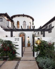 a white house with black trim on the front door and steps leading up to it