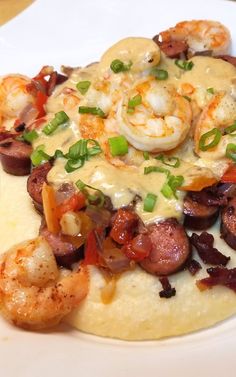 a white plate topped with shrimp and grits