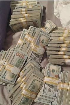 a pile of money sitting on top of a bed