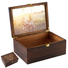 an open wooden box with a photo in it and the lid opened to show a man sitting on a swing