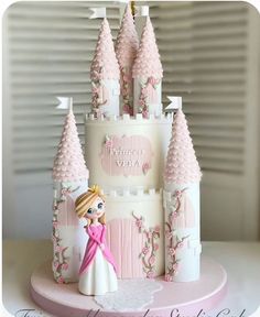 a princess castle cake is decorated with pink frosting