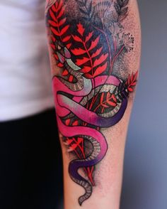 a woman's arm with a snake and flowers tattoo design on the left forearm