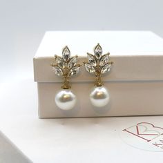 Bridal and bridesmaids large pearl and rhinestone fashion earrings. Wedding pearl drop crystal stud earrings.Sweet and tender, multiple leaf shaped rhinestones are clustered together with a larger round shaped pearl attached to it. The elegant studs add an extra feminine touch to your simple yet elegant look. Versatile and chic, the wedding style earrings will be a nice addition to a bridal outfit or suitable for any special occasion. DIMENSIONS: about 1.2"L x 0.8"WMATERIALS: Metal, faux pearls, Elegant Gold Crystal Pearl Earrings, Wedding Pearl Drop Crystal Earrings, Gold Crystal Pearl Earrings For Wedding, Gold Elegant Crystal Earrings For Bridesmaid, Glamorous Pearl Embellished Earrings As Gift, Glamorous Pearl Embellished Earrings For Gift, Elegant Pearl Earrings For Bridesmaid Gift, Pearl White Crystal Pearl Earrings For Gifts, Elegant Crystal Pearl Earrings For Gift