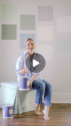 a woman sitting on top of a table next to paint cans