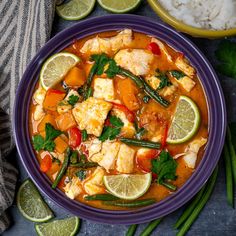 a purple bowl filled with chicken and vegetables next to rice, limes and cilantro